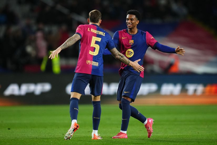 Deux footballeurs en maillot rouge et bleu, l'un avec le "5 Martínez" sur le dos, célèbrent leur victoire sur le terrain. Leurs sourires sont aussi éclatants que les cotes de Betway Arabia, les bras grands ouverts l'un vers l'autre au milieu des acclamations floues de la foule du stade en arrière-plan.