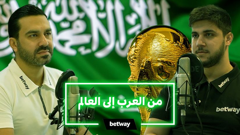 Two men sit with microphones before a green Saudi Arabian flag backdrop. A golden trophy stands between them, while a neon green box displays Arabic text. The betway arabia logo is emblazoned on their shirts and the bottom banner.