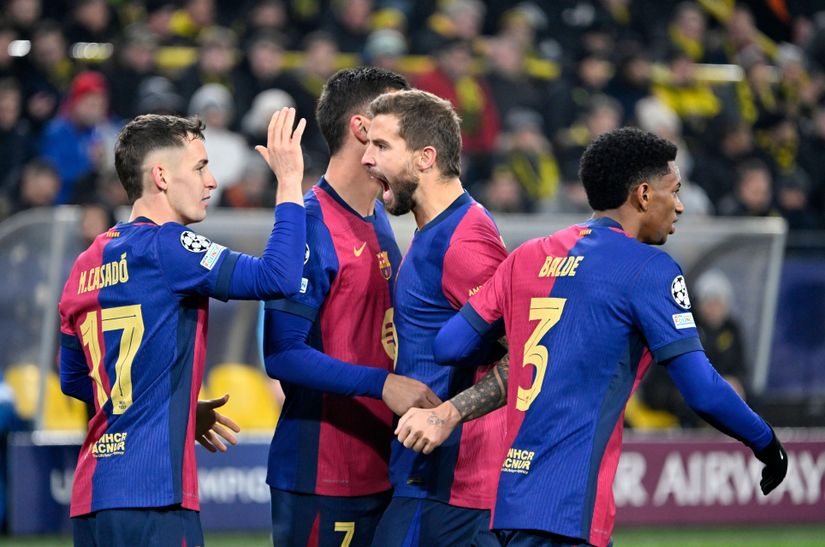A group of soccer players in blue and red jerseys celebrate on the field, energized like a winning Betway Arabia bet. One player raises his hand for a high-five as fans fill the stadium in yellow and black, reveling in the thrilling atmosphere.
