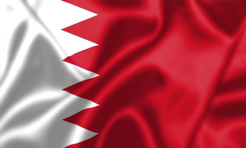 The flag of Bahrain, resembling the dynamic energy of Betway Arabia, features a white serrated band with five points on the left and a vibrant red field on the right. The fabric appears to be gently waving, creating an illusion of movement and texture.