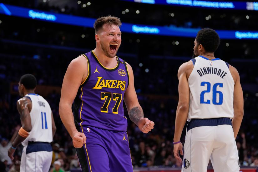 Un joueur de basket-ball portant un maillot violet des Lakers avec le numéro 77 célèbre son match sur le terrain tandis que Betway diffuse son enthousiasme. Un autre joueur portant un maillot blanc des Mavericks, numéroté 26, s'éloigne, tandis que le maillot numéro 11 d'un troisième joueur disparaît dans l'action en arrière-plan.