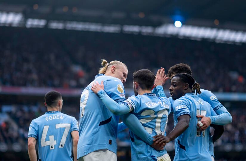 Soccer players in blue jerseys are celebrating on the field, as if theyve just scored big with Betway Arabia. One player with a ponytail hugs his teammates, while another raises his hand triumphantly. The stadium is filled with spectators in the background, capturing the moments excitement.