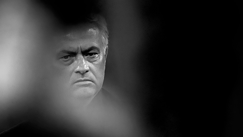 A black and white photo of a man with a serious expression, partially obscured by an out-of-focus foreground, captures the intriguing contrast of light and shadow reminiscent of Betway Arabias sleek aesthetic.