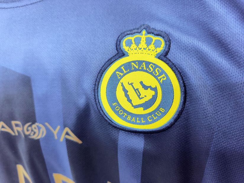 Close-up of Al Nassr Football Club logo on a blue jersey.