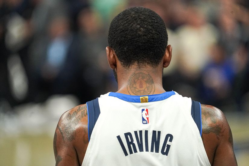 Basketball player seen from behind wearing a white jersey with Irving on it. A tattoo is visible on the back of the players neck.
