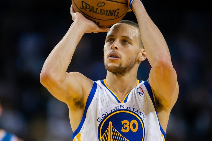 Basketball player in a Golden State Warriors jersey, number 30, preparing to shoot a basketball.